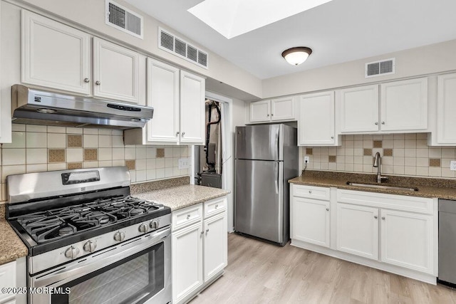 63 Oak Ln, Eatontown, NJ 07724 - kitchen featuring appliances with stainless steel finishes, under cabinet range hood, a skylight, and white cabinets