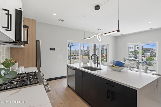 401 Boulevard 202, Seaside Heights, NJ 08751 - kitchen featuring dark cabinets, appliances with stainless steel finishes, light wood-style floors, a kitchen island with sink, and open floor plan