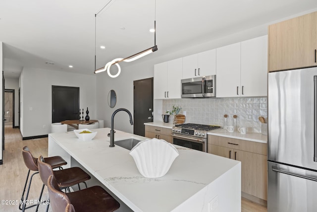 401 Boulevard 202, Seaside Heights, NJ 08751 - kitchen with appliances with stainless steel finishes, tasteful backsplash, a center island with sink, a kitchen breakfast bar, and light wood finished floors