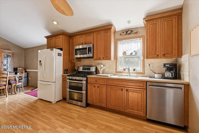 444 Cook Rd, Jackson, NJ 08527 - kitchen with stainless steel appliances, brown cabinetry, backsplash, light wood-style floors, and lofted ceiling