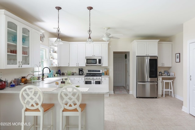 8001/2 Schoolhouse Rd, Brielle, NJ 08730 - kitchen featuring stainless steel appliances, a peninsula, light countertops, a breakfast bar area, and hanging light fixtures