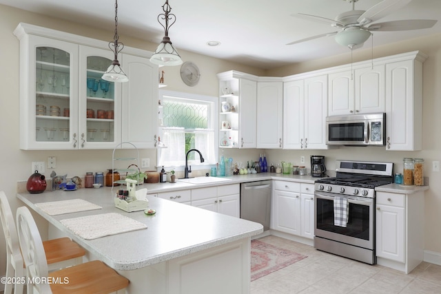 8001/2 Schoolhouse Rd, Brielle, NJ 08730 - kitchen with stainless steel appliances, a peninsula, glass insert cabinets, open shelves, and a breakfast bar area