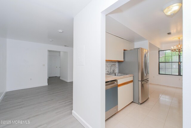 402 Hidden Village Dr Unit 402, Perth Amboy, NJ 08862 - kitchen featuring stainless steel appliances, a chandelier, light countertops, backsplash, and white cabinets
