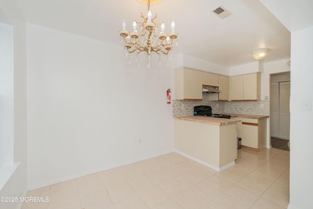 402 Hidden Village Dr Unit 402, Perth Amboy, NJ 08862 - kitchen with cream cabinets, stove, under cabinet range hood, a chandelier, and backsplash