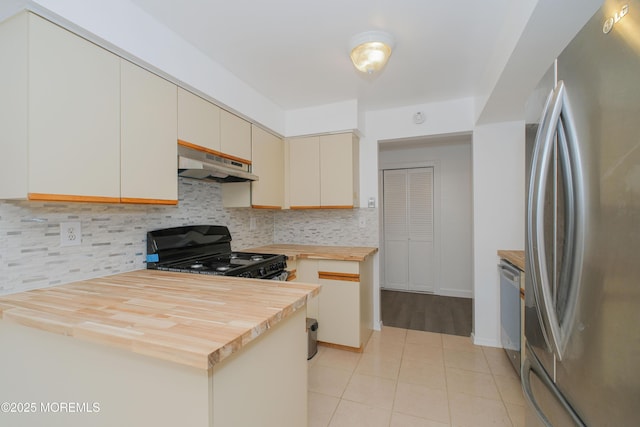 402 Hidden Village Dr Unit 402, Perth Amboy, NJ 08862 - kitchen featuring appliances with stainless steel finishes, under cabinet range hood, butcher block countertops, tasteful backsplash, and light tile patterned floors