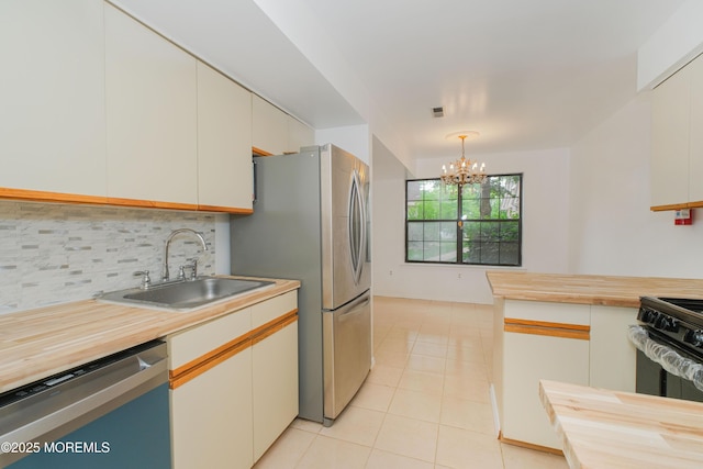 402 Hidden Village Dr Unit 402, Perth Amboy, NJ 08862 - kitchen featuring appliances with stainless steel finishes, butcher block counters, decorative backsplash, a chandelier, and light tile patterned floors