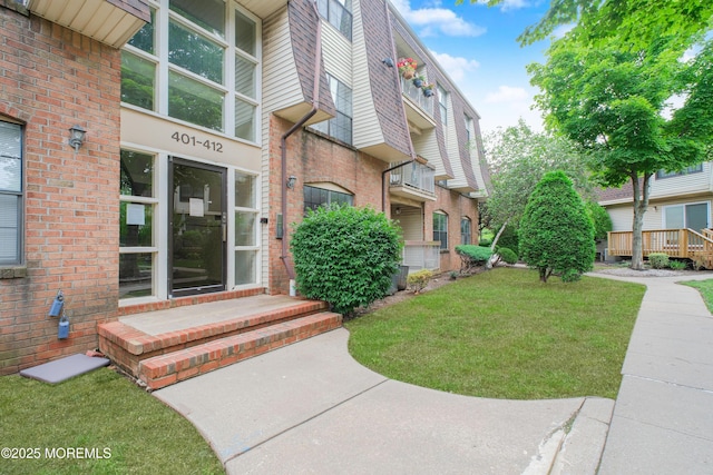 402 Hidden Village Dr Unit 402, Perth Amboy, NJ 08862 - doorway to property featuring brick siding and a lawn