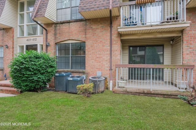402 Hidden Village Dr Unit 402, Perth Amboy, NJ 08862 - view of property exterior featuring a balcony, a yard, and brick siding