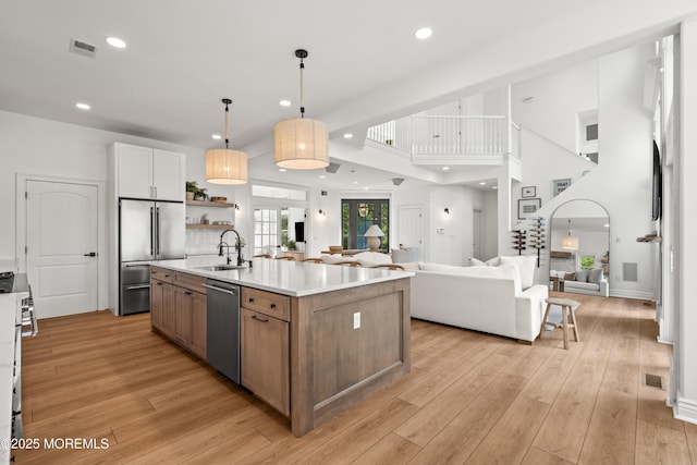 199-203 Lake Ave, Island Heights, NJ 08732 - kitchen featuring stainless steel appliances, open floor plan, light countertops, an island with sink, and light wood-style floors