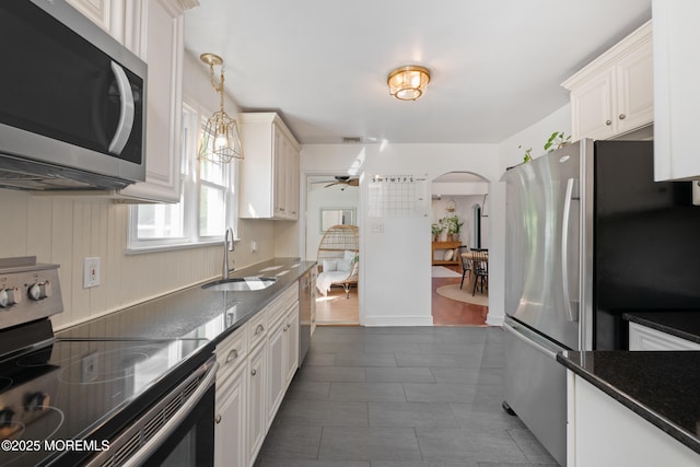 79 Lake Shore Dr, Red Bank, NJ 07701 - kitchen featuring appliances with stainless steel finishes, arched walkways, a ceiling fan, hanging light fixtures, and white cabinets