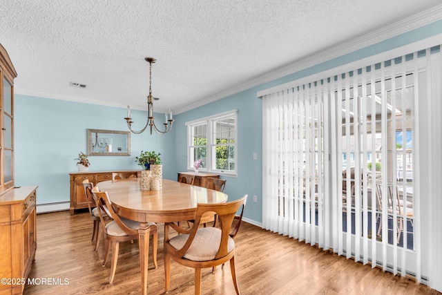 82 Spinnaker Ct, Bayville, NJ 08721 - dining space with a baseboard heating unit, a textured ceiling, wood finished floors, crown molding, and a chandelier