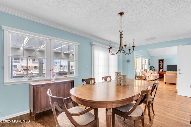 82 Spinnaker Ct, Bayville, NJ 08721 - dining space with light wood-type flooring, a chandelier, a textured ceiling, and ornamental molding