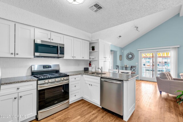 82 Spinnaker Ct, Bayville, NJ 08721 - kitchen with stainless steel appliances, a textured ceiling, a peninsula, light wood-style floors, and white cabinetry