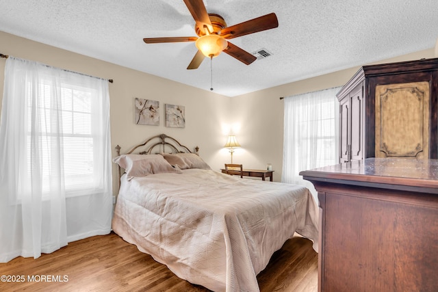 82 Spinnaker Ct, Bayville, NJ 08721 - bedroom with multiple windows, light wood-type flooring, a textured ceiling, and ceiling fan