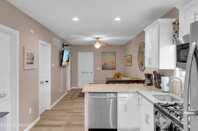 241 Hiering Ave, Seaside Heights, NJ 08751 - kitchen featuring stainless steel appliances, a peninsula, ceiling fan, light wood-style flooring, and white cabinetry