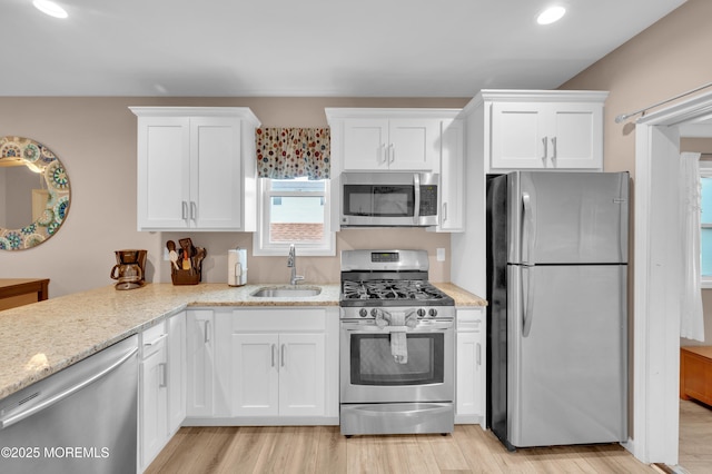 241 Hiering Ave, Seaside Heights, NJ 08751 - kitchen with stainless steel appliances, white cabinetry, light wood finished floors, light stone counters, and recessed lighting