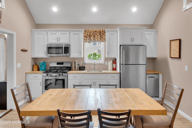 241 Hiering Ave, Seaside Heights, NJ 08751 - kitchen featuring appliances with stainless steel finishes, white cabinets, light wood-style flooring, recessed lighting, and lofted ceiling