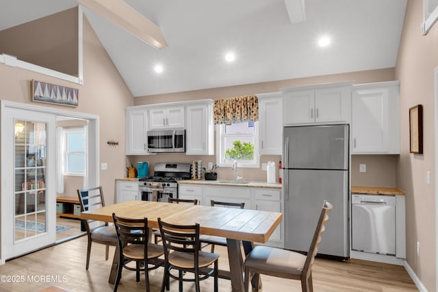241 Hiering Ave, Seaside Heights, NJ 08751 - kitchen featuring appliances with stainless steel finishes, light wood-type flooring, white cabinets, light countertops, and high vaulted ceiling