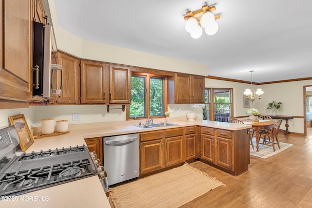 22 Hunt Rd, Freehold, NJ 07728 - kitchen featuring appliances with stainless steel finishes, a chandelier, a peninsula, brown cabinetry, and crown molding