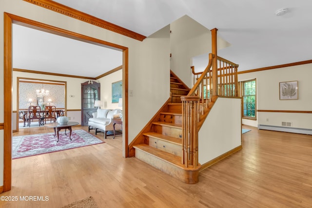 22 Hunt Rd, Freehold, NJ 07728 - stairway featuring ornamental molding, a chandelier, wood finished floors, and a baseboard heating unit
