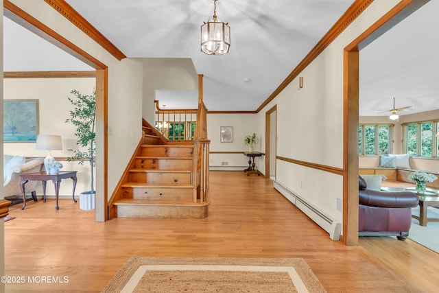 22 Hunt Rd, Freehold, NJ 07728 - stairs with a baseboard heating unit, wood finished floors, ornamental molding, a chandelier, and a ceiling fan