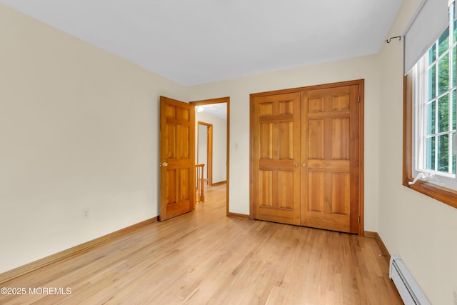 22 Hunt Rd, Freehold, NJ 07728 - unfurnished bedroom with a baseboard heating unit, light wood-style flooring, and a closet