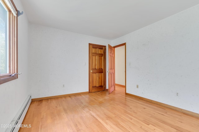 22 Hunt Rd, Freehold, NJ 07728 - empty room with a baseboard heating unit and light wood-style floors