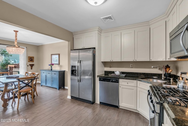 134 Marina Bay Ct, Highlands, NJ 07732 - kitchen featuring appliances with stainless steel finishes, a chandelier, light wood-type flooring, and dark stone countertops