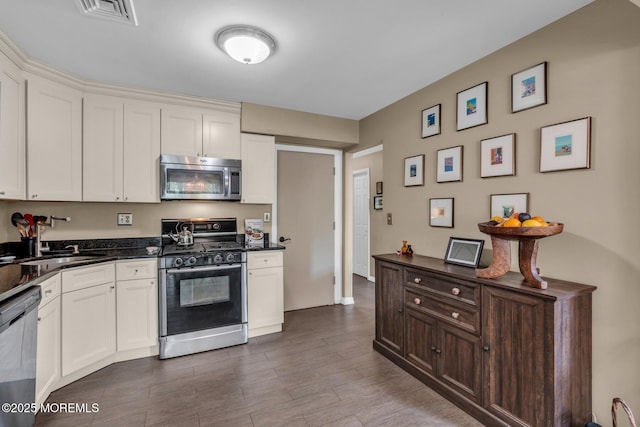 134 Marina Bay Ct, Highlands, NJ 07732 - kitchen with appliances with stainless steel finishes, white cabinetry, and dark wood-style flooring