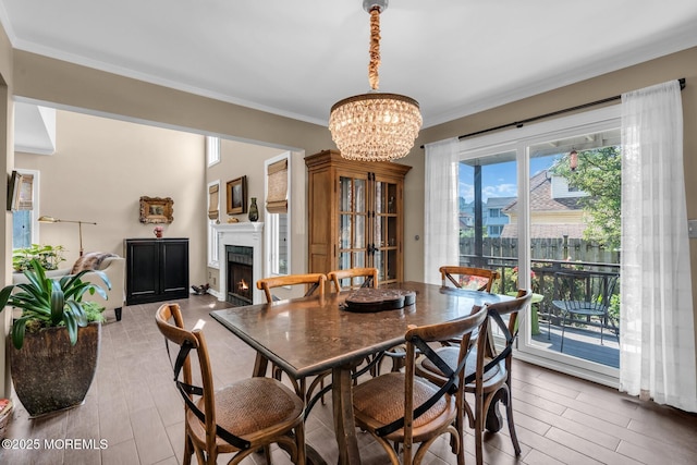 134 Marina Bay Ct, Highlands, NJ 07732 - dining room featuring crown molding, a chandelier, a lit fireplace, and wood finished floors