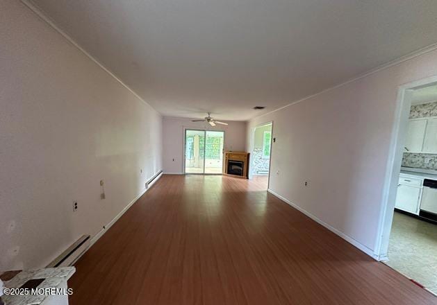 10 Arnold St, Brick, NJ 08724 - unfurnished living room with a baseboard heating unit, ceiling fan, a fireplace, and wood finished floors