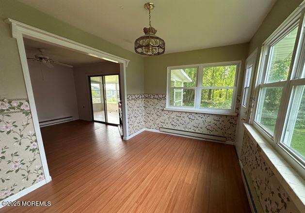 10 Arnold St, Brick, NJ 08724 - spare room with wood finished floors, a baseboard heating unit, baseboard heating, ceiling fan, and wallpapered walls