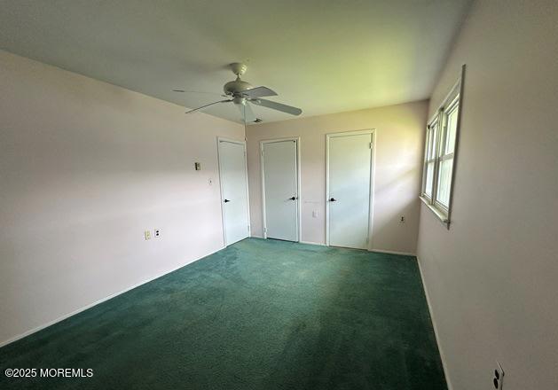 10 Arnold St, Brick, NJ 08724 - unfurnished bedroom with two closets, dark colored carpet, and a ceiling fan