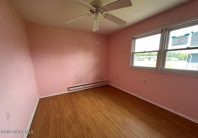 10 Arnold St, Brick, NJ 08724 - empty room featuring baseboard heating, wood finished floors, and a ceiling fan