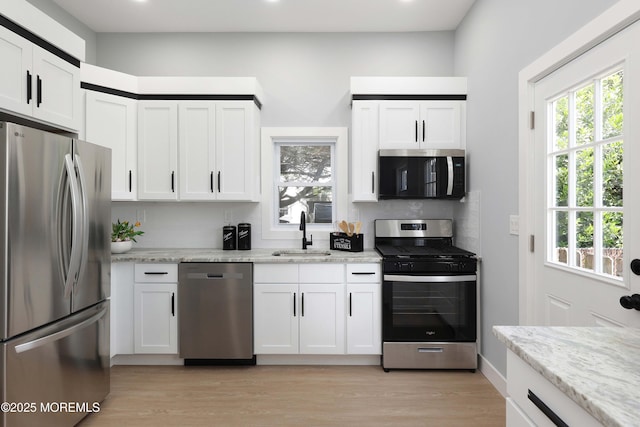 623 Central Ave, Union Beach, NJ 07735 - kitchen with appliances with stainless steel finishes, light wood-type flooring, white cabinetry, light stone countertops, and recessed lighting