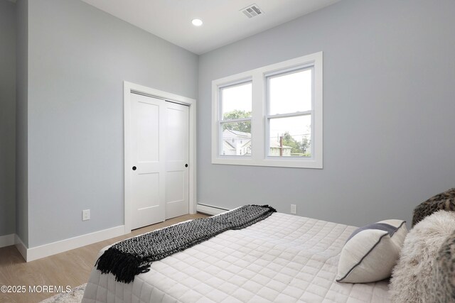 623 Central Ave, Union Beach, NJ 07735 - bedroom featuring wood finished floors, a closet, baseboard heating, and recessed lighting