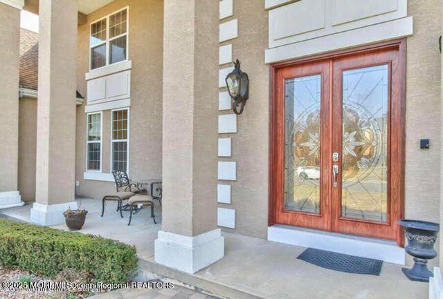 6 Meadow Run Ct, Jackson, NJ 08527 - view of exterior entry with french doors, covered porch, and stucco siding