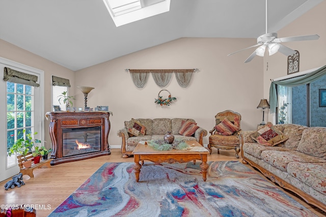 2 Apache Dr, Toms River, NJ 08753 - living area with vaulted ceiling, wood finished floors, a skylight, ceiling fan, and a glass covered fireplace