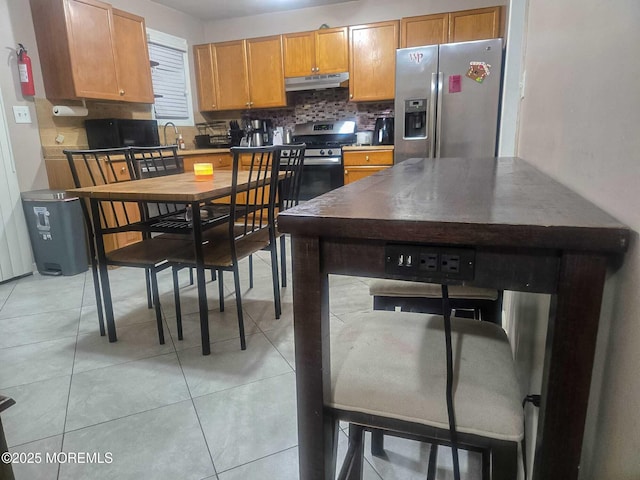 207 Delaware Ave, Cliffwood, NJ 07721 - kitchen with stainless steel appliances, under cabinet range hood, decorative backsplash, and light tile patterned flooring