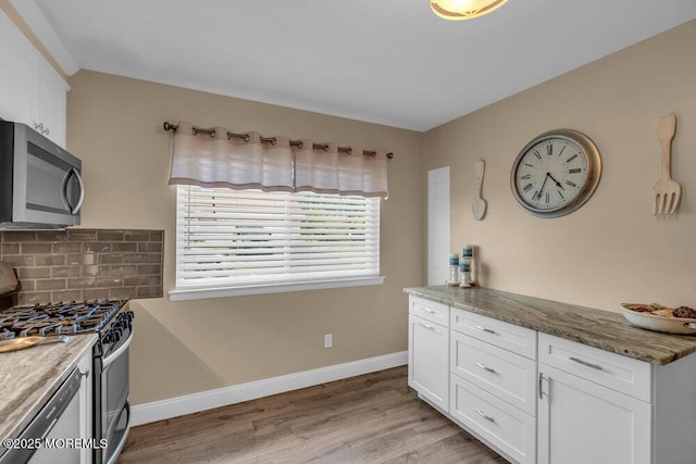 26 Kathy Ct, Brick, NJ 08724 - kitchen featuring stainless steel appliances, white cabinets, light wood-style floors, decorative backsplash, and stone counters