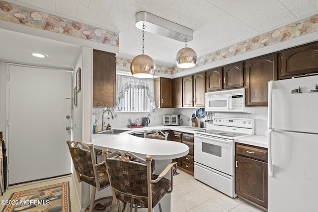51 Hiering Ave Unit C 12, Seaside Heights, NJ 08751 - kitchen with white appliances, dark brown cabinetry, light countertops, decorative light fixtures, and a peninsula