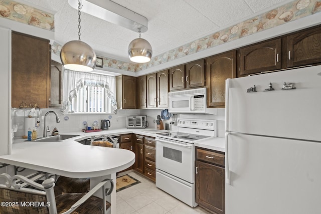 51 Hiering Ave Unit C 12, Seaside Heights, NJ 08751 - kitchen with white appliances, dark brown cabinets, light countertops, and wallpapered walls