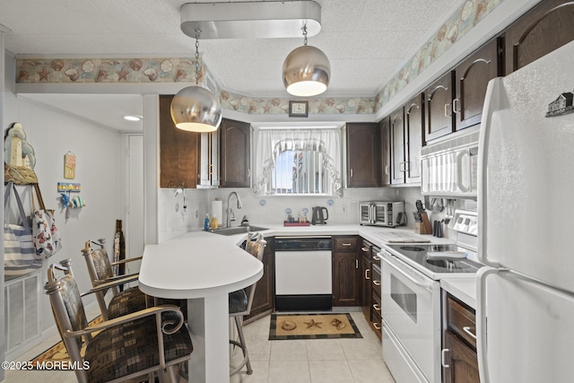 51 Hiering Ave Unit C 12, Seaside Heights, NJ 08751 - kitchen featuring white appliances, dark brown cabinets, light countertops, and plenty of natural light
