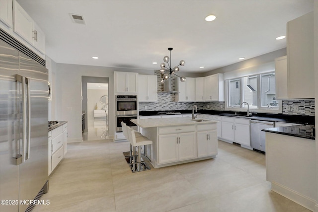 1 Country Club Dr, Deal, NJ 07723 - kitchen featuring stainless steel appliances, decorative backsplash, a chandelier, a kitchen island with sink, and white cabinets