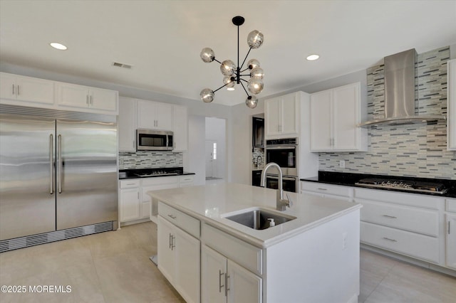 1 Country Club Dr, Deal, NJ 07723 - kitchen featuring appliances with stainless steel finishes, wall chimney exhaust hood, tasteful backsplash, a chandelier, and light tile patterned floors