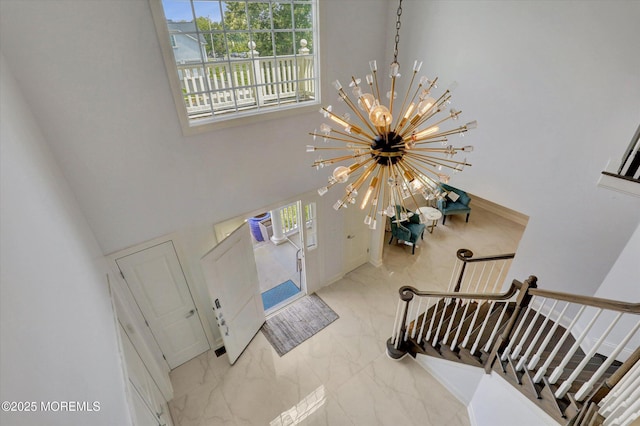 1 Country Club Dr, Deal, NJ 07723 - entryway with marble look tile flooring, stairs, a chandelier, and a towering ceiling