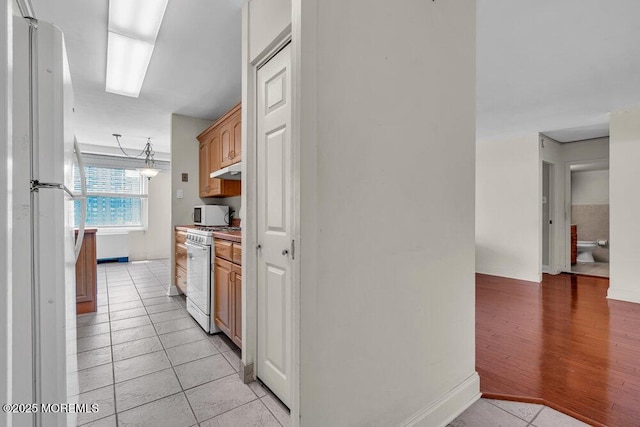 101 S Plaza Pl Unit 806, Atlantic City, NJ 08401 - kitchen featuring white appliances, light tile patterned floors, under cabinet range hood, and light countertops