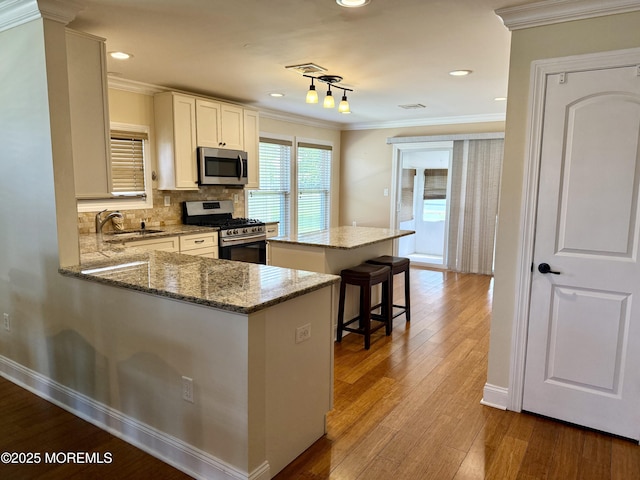3 Tivoli St, Toms River, NJ 08757 - kitchen with appliances with stainless steel finishes, crown molding, a center island, white cabinets, and backsplash