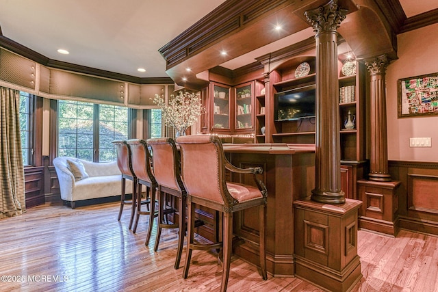 2 Red Oak, Holmdel, NJ 07733 - bar area featuring decorative columns, ornamental molding, light wood-style flooring, a decorative wall, and wainscoting