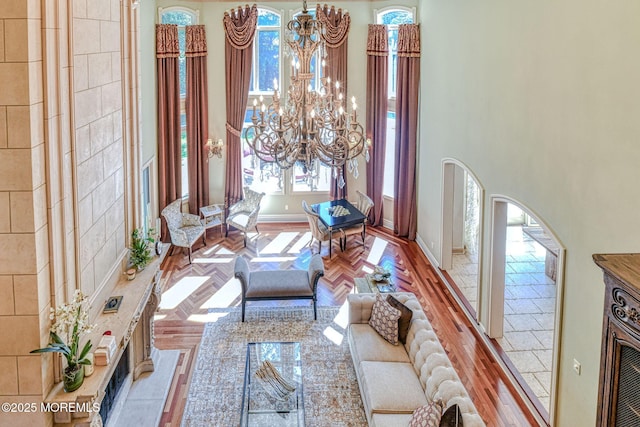 2 Red Oak, Holmdel, NJ 07733 - living room featuring a chandelier, a towering ceiling, wood finished floors, and arched walkways